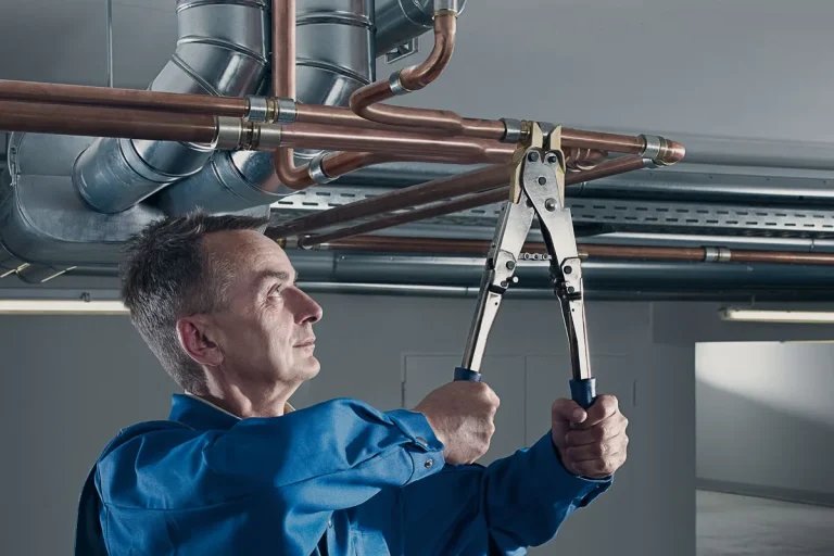 Technician installing VULKAN LOKRING braze-free connections on copper refrigerant lines with a hand tool